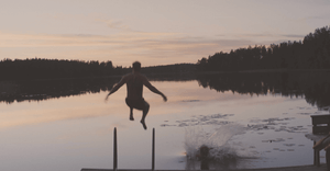 Skandinavisk sommar med RMFB, människor som hoppar från en brygga i solnedgången 